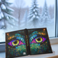 Open book with colorful eye design on a windowsill with a snowy outdoor view.